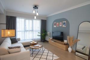 - un salon avec un canapé blanc et une télévision dans l'établissement Cozy 2br Apt Near Vialand Mall With Nespresso, à Istanbul