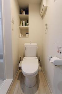 La salle de bains est pourvue d'une douche et de toilettes blanches. dans l'établissement Shibuya Anon #A204, à Tokyo