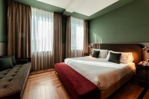 a hotel room with a large bed and a couch at Bianca Maria Palace Hotel in Milan