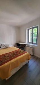 a bedroom with a bed and a desk and a window at Maison avec vue panoramique in Trigance