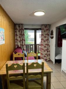 a dining room with a wooden table and chairs at L'Épicéa - Praz in Praz-sur-Arly