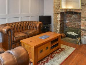a living room with a leather couch and a coffee table at The Winchester in Deal