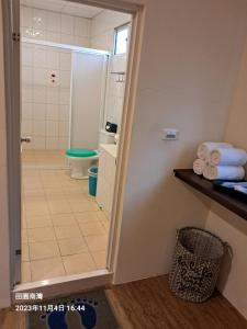 a bathroom with a shower and a toilet and a sink at Tianyuan Nanwan Homestay in Nanwan