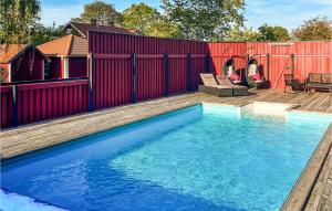 - une piscine dans un jardin avec clôture rouge dans l'établissement Gorgeous Apartment In Sdra Vi With Kitchen, à Södra Vi