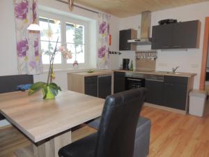 a kitchen with a wooden table and black chairs at Appartments Rindisplatzl in Schladming