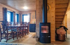 comedor con chimenea en una casa de madera en 4 Bedroom Amazing Home In Vatnestrm, en Svaland