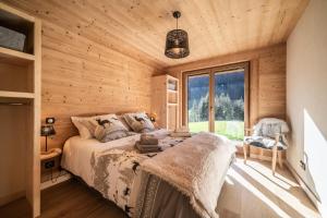 um quarto com uma cama num chalé de madeira em Le Chalet des Praz em Abondance