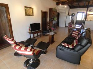 een woonkamer met lederen stoelen en een televisie bij Castalan in Gaas