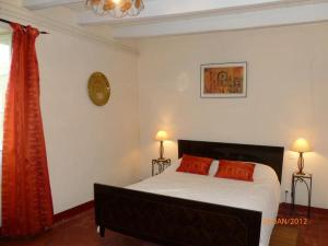 een slaapkamer met een bed met witte lakens en oranje kussens bij Castalan in Gaas