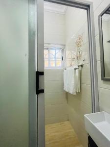 ein Bad mit einer Dusche und einem Waschbecken in der Unterkunft Taari's Place in Accra