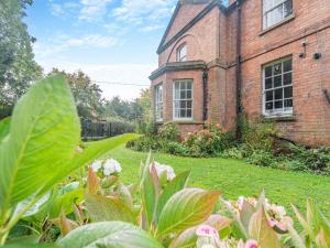 an old brick building with a garden in front of it at North Lodge-uk45599 in Southwell