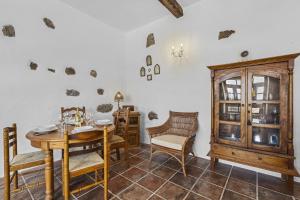 ein Esszimmer mit einem Tisch und Stühlen sowie einem Schrank in der Unterkunft Casa El Burro in La Vegueta