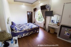 a bedroom with a bed and a large window at Da Lat LUCINA Boutique Hotel in Da Lat