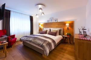 a bedroom with a large bed and a red chair at Zur Wurschtekammer in Lichtenau