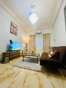 ein Wohnzimmer mit einem Sofa und einem Flachbild-TV in der Unterkunft Taari's Place in Accra