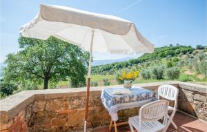 a table and chairs with an umbrella on a stone wall at Schivanoia 3 in Bagno Vignoni