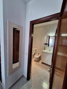 a bathroom with a toilet and a sink and a door at Apartamento California 3 in Miami Platja