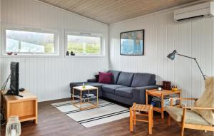 un salon avec un canapé bleu et une télévision dans l'établissement Lovely Home In Vanse With House Sea View, à Vanse