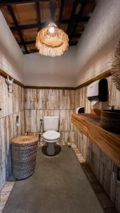 a bathroom with a toilet and a chandelier at Isla Beach Hotel in Pecém
