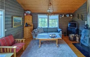 ein Wohnzimmer mit einem Sofa und einem Tisch in der Unterkunft Cozy Home In Vikes With House Sea View in Vikeså