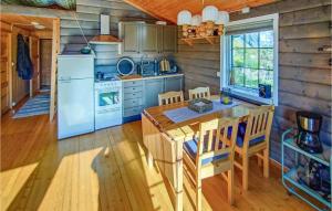 eine Küche mit einem Tisch und Stühlen sowie einem Kühlschrank in der Unterkunft Cozy Home In Vikes With House Sea View in Vikeså