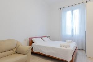 米蘭的住宿－JOIVY Minimalistic flat near the centre，一间卧室配有一张床、一张沙发和一个窗口