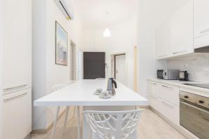 米蘭的住宿－JOIVY Minimalistic flat near the centre，白色的厨房配有白色的柜台和椅子