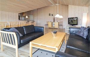 a living room with a couch and a table at Beautiful Home In Rdby With 4 Bedrooms, Sauna And Wifi in Kramnitse