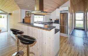 una cucina con pannelli in legno e bancone con sgabelli di 4 Bedroom Lovely Home In Rdby a Kramnitse