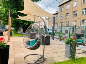 - une terrasse avec 2 chaises suspendues et un parasol dans l'établissement Włodary Tennis Junior, à Częstochowa