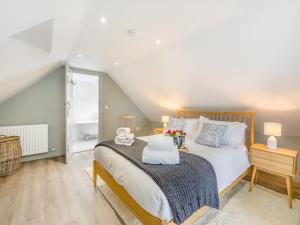 a bedroom with a large bed and a bathroom at Blackside Cottage in stunning Ayrshire countryside in Mauchline