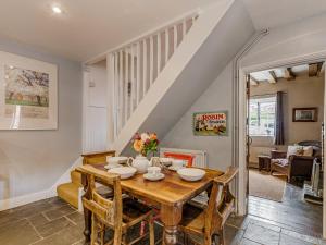 a dining room with a wooden table and chairs at Orions Cottage in Chilham