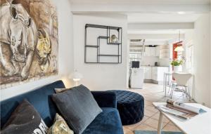 uma sala de estar com um sofá azul e uma cozinha em 1 Bedroom Beautiful Apartment In Gilleleje em Gilleleje