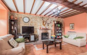 sala de estar con chimenea y TV en Gorgeous Home In Las Regueras With Kitchen, en Santullano