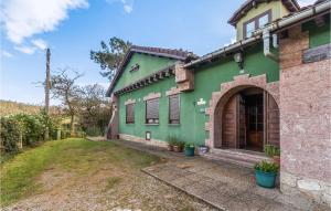 una casa verde con un patio delante en Gorgeous Home In Las Regueras With Kitchen, en Santullano