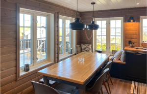 a dining room with a wooden table and windows at 5 Bedroom Beautiful Home In Gol in Golsfjellet