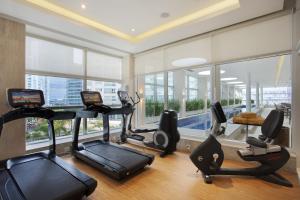 um ginásio com equipamento cardiovascular numa sala com janelas em Windsor Brasilia Hotel em Brasília