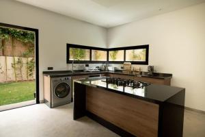 a kitchen with a stove and a washing machine at Villa Design à Marrakech in Marrakech