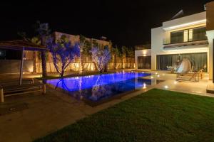 a swimming pool in front of a house at night at Villa Design à Marrakech in Marrakech