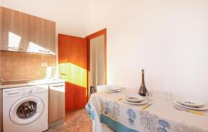 - une cuisine avec une table et un lave-linge dans l'établissement Il Porto, à Porto Torres