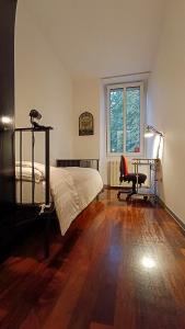 een slaapkamer met een bed, een bureau en een stoel bij Casa Julí: 70mq-Centro-Trieste in Trieste
