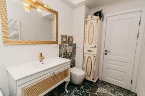uma casa de banho com um lavatório, um WC e um espelho. em BEAUTIFUL & COMFORTABLE em Chisinau