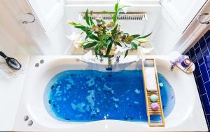 een badkamer met een blauw bad en een vaas met bloemen bij Hanover 71 Suites in Edinburgh