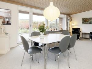 a dining room with a white table and chairs at 6 person holiday home in r sk bing in Ærøskøbing
