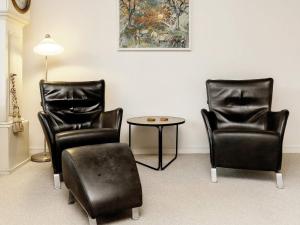 two black chairs and a table in a room at 6 person holiday home in r sk bing in Ærøskøbing
