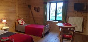 a bedroom with two beds and a table and a window at Le Jura en toutes saisons piscine, SPA, climatisation, balades 2cv in Bonlieu