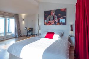 una camera da letto con un grande letto bianco con tende rosse di Tralala Hotel Montreux a Montreux