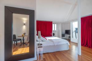 a bedroom with a bed with red curtains and a mirror at Tralala Hotel Montreux in Montreux