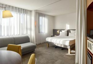 パリにあるB&B HOTEL Paris Nord 18èmeのベッドとソファ付きのホテルルーム