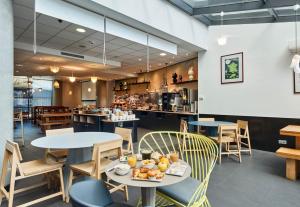 un restaurant avec des tables, des chaises et un comptoir dans l'établissement B&B HOTEL Paris Nord 18ème, à Paris